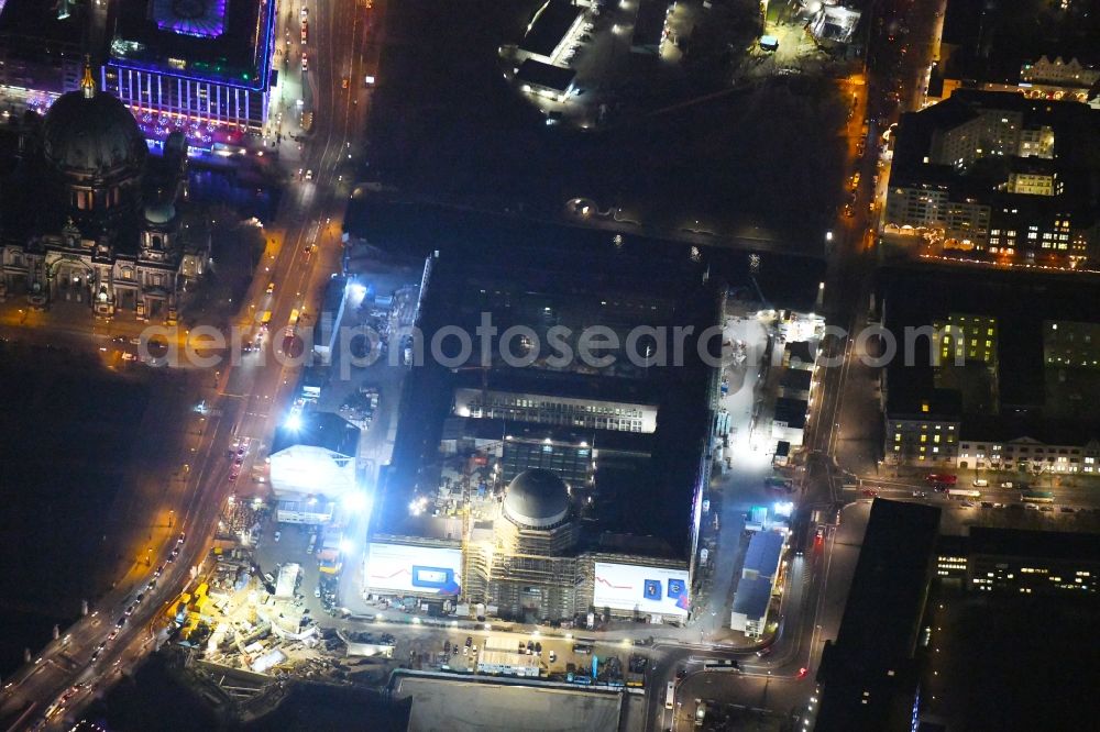 Aerial image at night Berlin - Night lighting Construction site for the new building the largest and most important cultural construction of the Federal Republic, the building of the Humboldt Forum in the form of the Berlin Palace