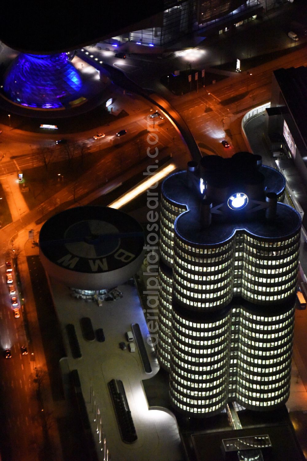 München at night from the bird perspective: Night lighting administration building of the company Vierzylinof of BMW AG in the district Milbertshofen-Am Hart in Munich in the state Bavaria, Germany