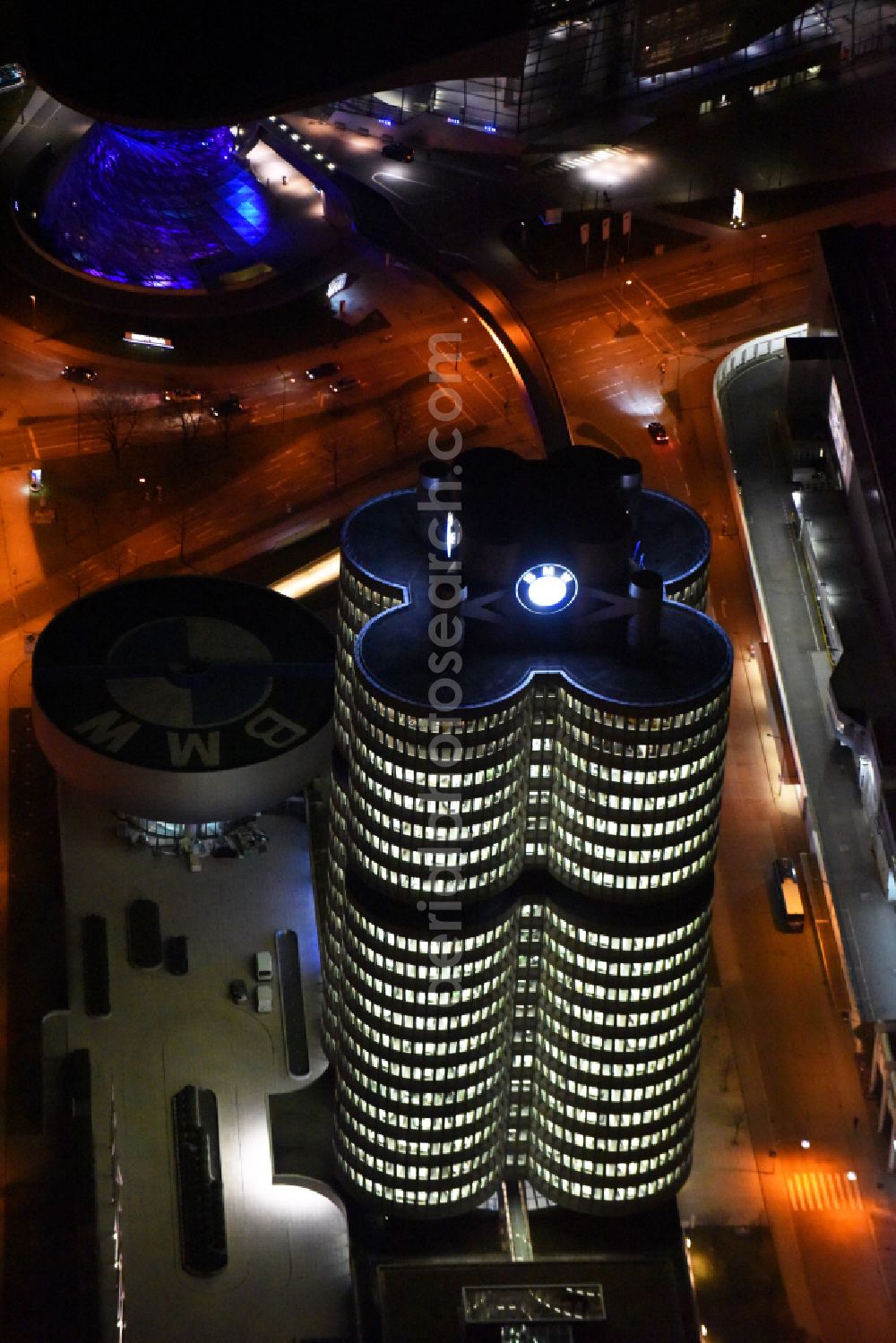 Aerial photograph at night München - Night lighting administration building of the company Vierzylinof of BMW AG in the district Milbertshofen-Am Hart in Munich in the state Bavaria, Germany