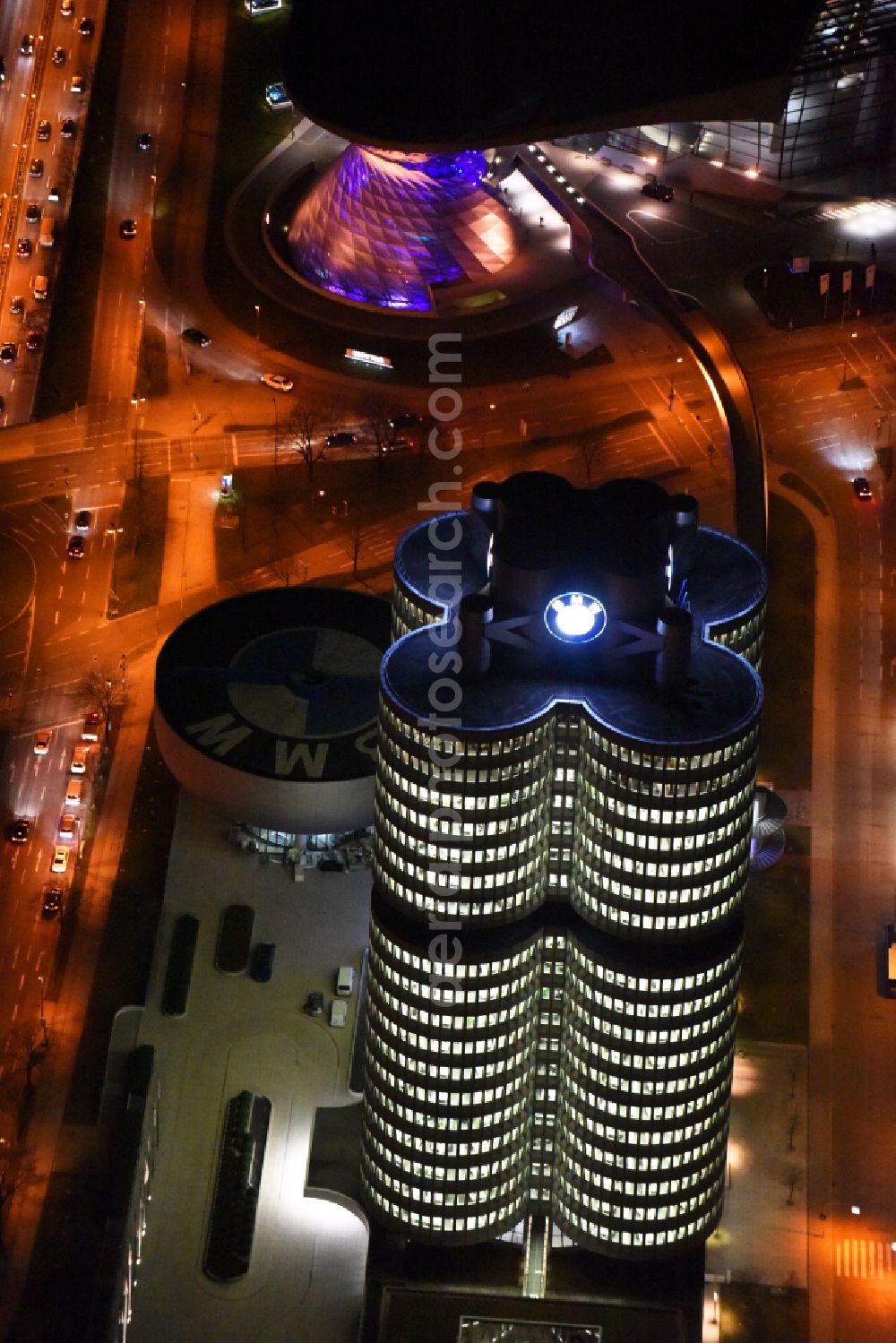 Aerial image at night München - Night lighting administration building of the company Vierzylinof of BMW AG in the district Milbertshofen-Am Hart in Munich in the state Bavaria, Germany