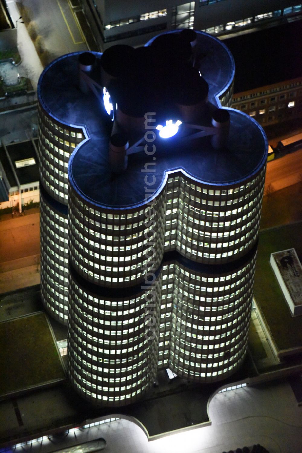 München at night from above - Night lighting administration building of the company Vierzylinof of BMW AG in the district Milbertshofen-Am Hart in Munich in the state Bavaria, Germany