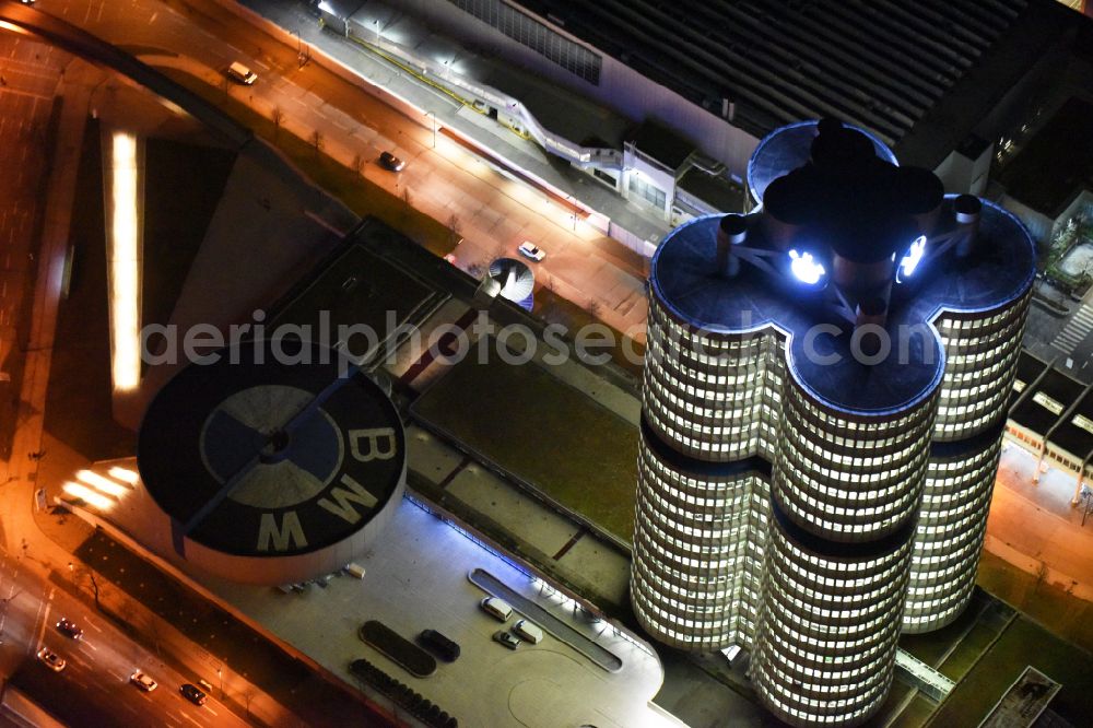 Aerial photograph at night München - Night lighting administration building of the company Vierzylinof of BMW AG in the district Milbertshofen-Am Hart in Munich in the state Bavaria, Germany