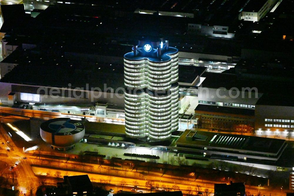 Aerial photograph at night München - Night lighting administration building of the company Vierzylinof of BMW AG in the district Milbertshofen-Am Hart in Munich in the state Bavaria, Germany