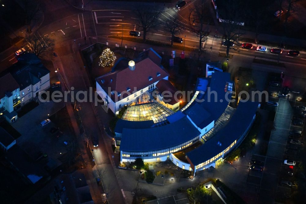 Neuruppin at night from above - Night lighting Banking administration building of the financial services company Sparkasse Ostprignitz-Ruppin - Geschaeftsstelle on Fontaneplatz in Neuruppin in the state Brandenburg, Germany