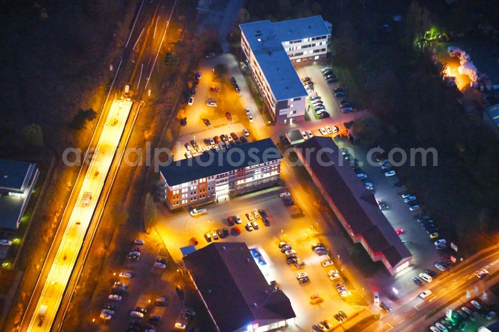 Aerial photograph at night Strausberg - Night lighting Administrative building of the State Authority Agentur fuer Arbeit Strausberg on Proetzeler Chaussee in Strausberg in the state Brandenburg, Germany