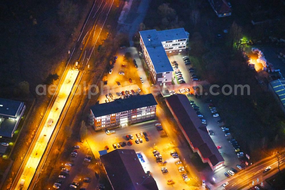 Aerial image at night Strausberg - Night lighting Administrative building of the State Authority Agentur fuer Arbeit Strausberg on Proetzeler Chaussee in Strausberg in the state Brandenburg, Germany