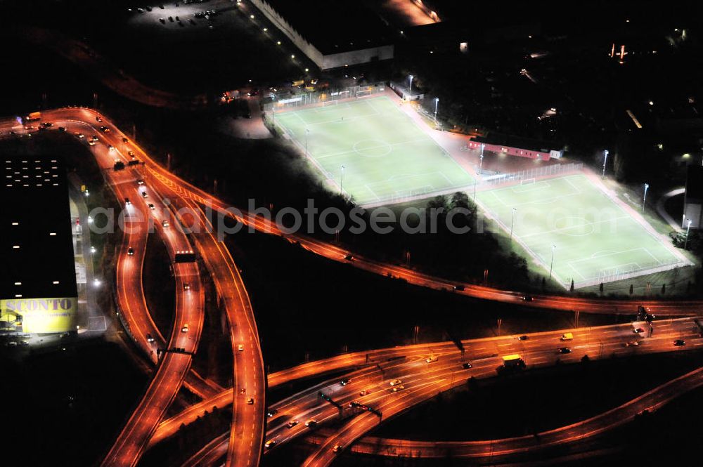 Berlin at night from the bird perspective: Nachtluftbild vom Areal des Autobahndreieck der Stadtautobahn A100 / A113 im Bereich Grenzallee / Spätstrasse am Sieversufer in Berlin - Neukölln. Night shot area of the junction of the A100 / A113 on border Allee / Spätstreet on Sievers bank in Berlin district Neukölln.