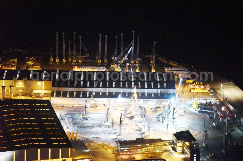 Rostock at night from the bird perspective: Night view company grounds and facilities of Liebherr-MCCtec GmbH in Rostock in the state Mecklenburg - Western Pomerania