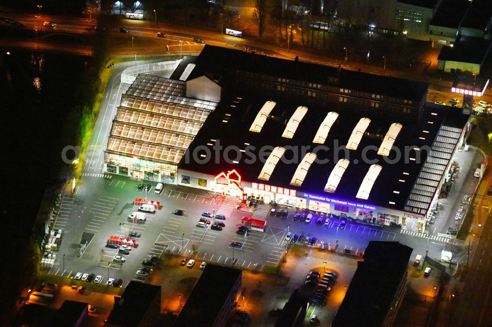 Berlin at night from the bird perspective: Night lighting Building of the construction market Bauhaus Schnellerstrasse - federal road B96a - Karlshorster Strasse in the district Treptow in Berlin