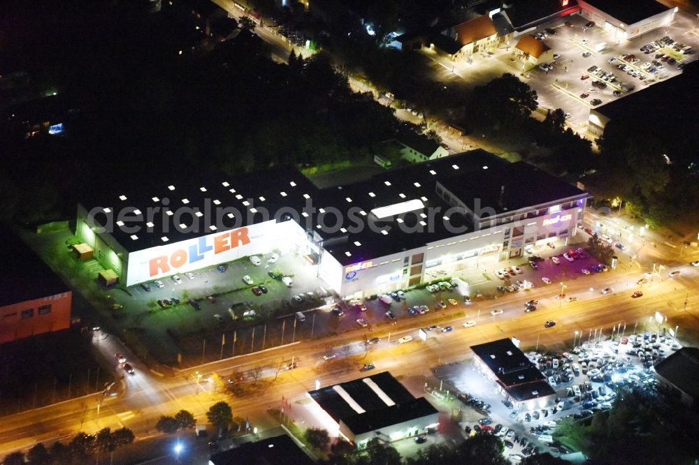 Aerial photograph at night Berlin - Night view Building of the store - furniture market Roller Moebel adjacent to the fitness studio McFit in the Hoenower Strasse corner federal road B1 in Mahlsdorf in Berlin