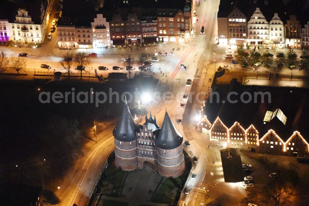 Lübeck at night from the bird perspective: Night view holsten Gate in the city center of the old town - center of Luebeck in Schleswig-Holstein