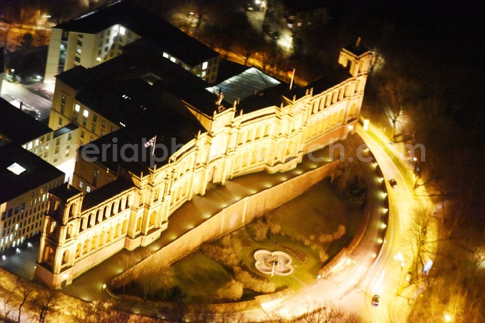 Aerial image at night München - Night view of palatial building Maximilianeum in the Haidhausen part of Munich in the state of Bavaria. The historic building is located on the Maximilian Bridge and includes the foundation Maximilianeum and has been seat of the Bavarian parliament. Because of its distinct facade and adjacent park with fountain, it is one of the famous tourist sites of the city