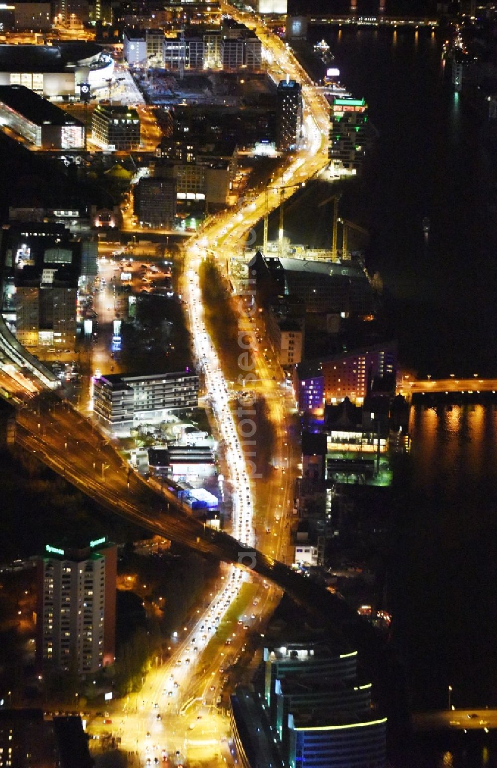 Berlin at night from the bird perspective: Night view of the district Friedrichshain along the Holzmarktstrasse - Stralauer Platz and the East Side Gallery. In the picture the suburban train stations tracks Ostbahnhof in Berlin