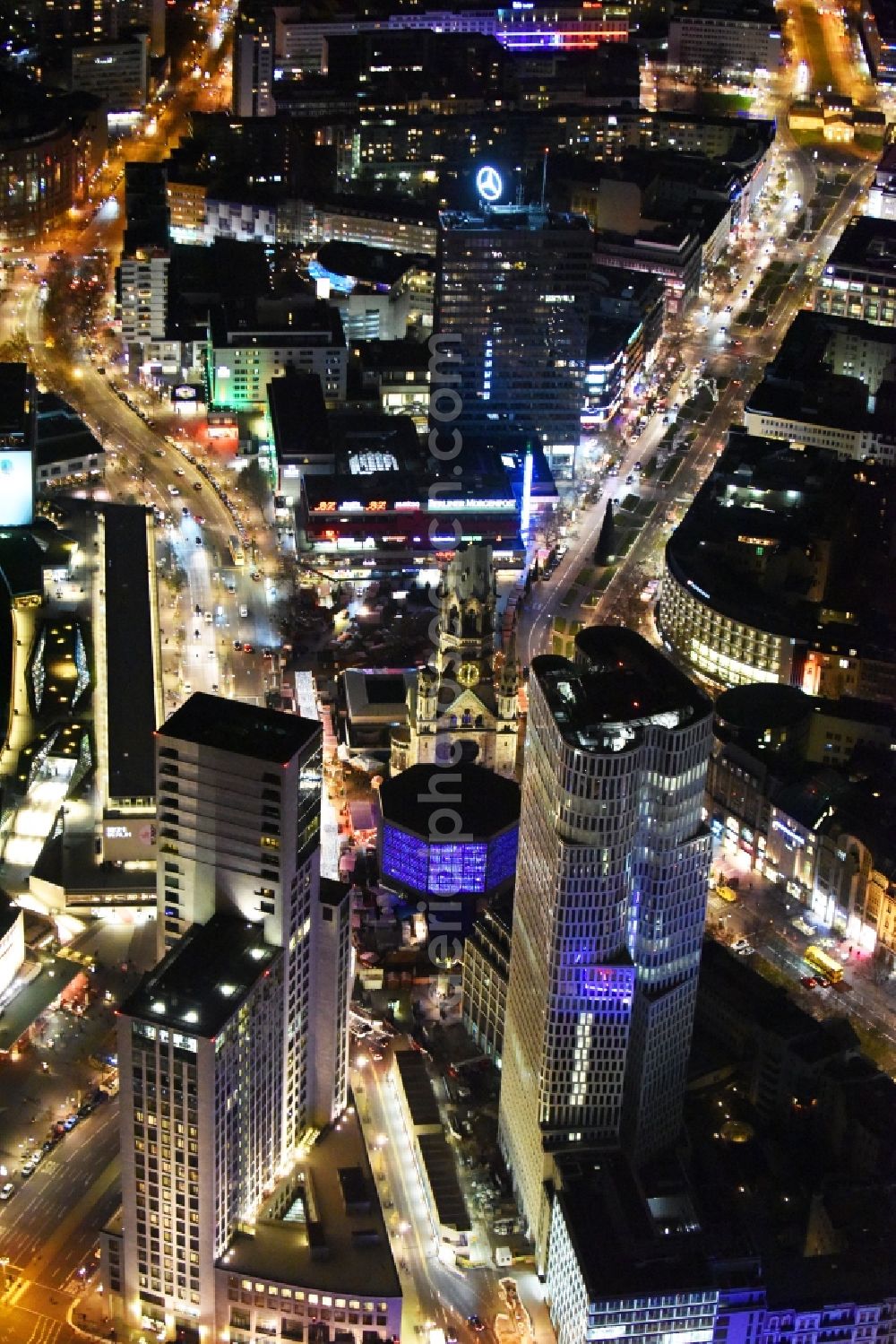 Aerial photograph at night Berlin - Night view group of buildings alongside the S-Bahn-track between the streets Kurfuerstendamm und Kantstrasse in the district Berlin Charlottenburg. You can see the CityQuartier Neues Kanzler-Eck, the highrise Zoofenster and the church Kaiser-Wilhelm-Gedaechtniskirche