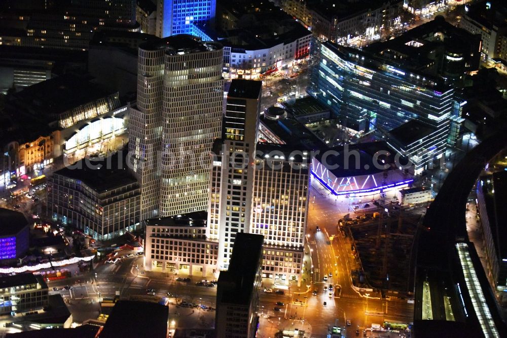 Berlin at night from the bird perspective: Night view group of buildings alongside the S-Bahn-track between the streets Kurfuerstendamm und Kantstrasse in the district Berlin Charlottenburg. You can see the CityQuartier Neues Kanzler-Eck, the highrise Zoofenster and the church Kaiser-Wilhelm-Gedaechtniskirche