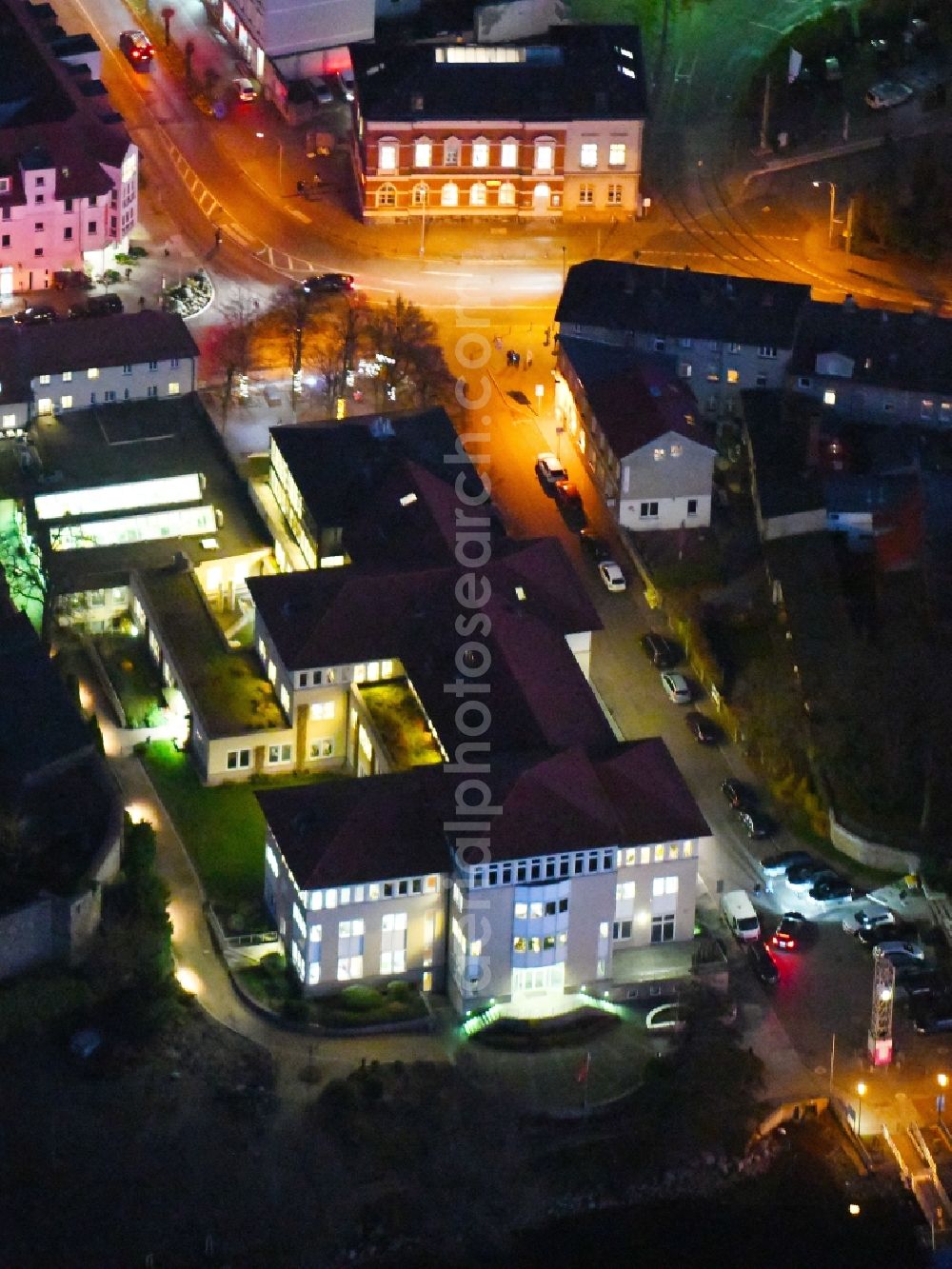 Strausberg at night from the bird perspective: Night lighting Banking administration building of the financial services company Sparkasse on Karl-Liebknecht-Strasse coner Grosse Strasse in Strausberg in the state Brandenburg, Germany