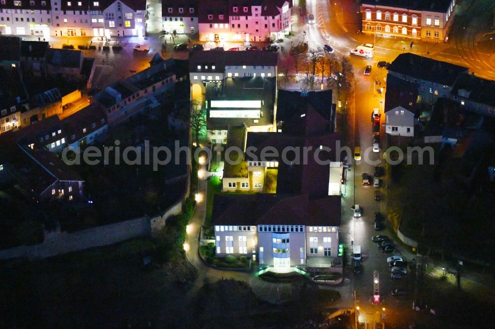 Aerial image at night Strausberg - Night lighting Banking administration building of the financial services company Sparkasse on Karl-Liebknecht-Strasse coner Grosse Strasse in Strausberg in the state Brandenburg, Germany