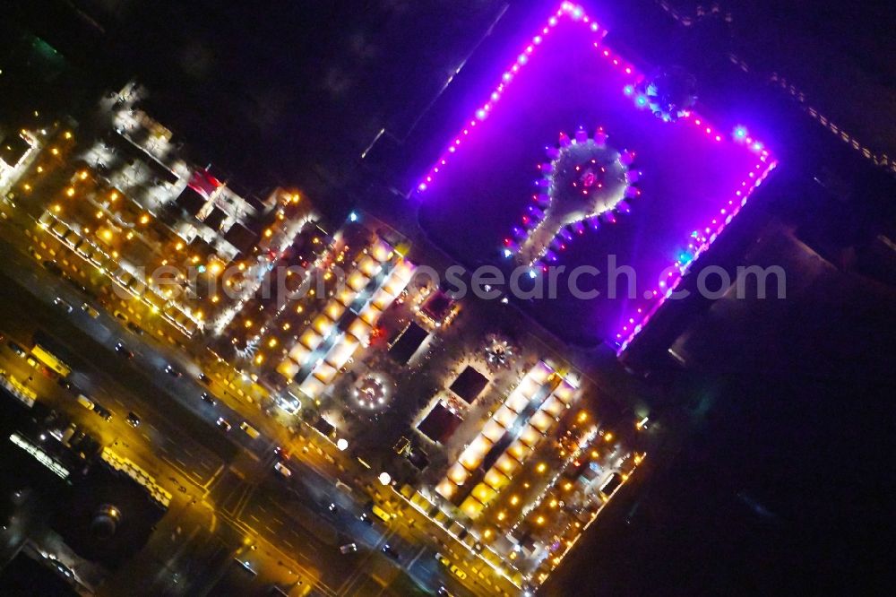 Berlin at night from the bird perspective: Night view of christmassy market event grounds and sale huts and booths am Schloss Charlotteburg in the district Bezirk Charlottenburg-Wilmersdorf in Berlin