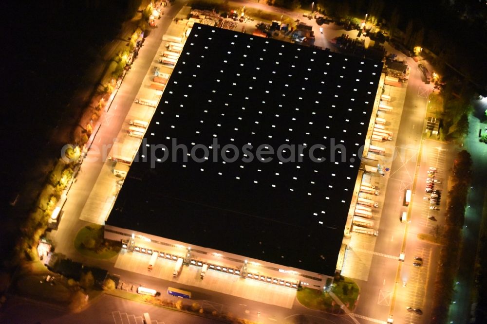 Berlin at night from the bird perspective: Night aerial image of the building complex and grounds of the logistics center of Kaiser's Tengelmann AG in the district of Tempelhof-Schoeneberg in Berlin in Germany. The illuminated hall is located on Ringstrasse