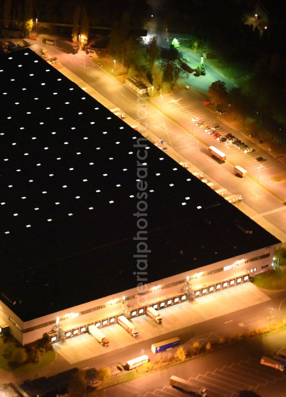 Aerial photograph at night Berlin - Night aerial image of the building complex and grounds of the logistics center of Kaiser's Tengelmann AG in the district of Tempelhof-Schoeneberg in Berlin in Germany. The illuminated hall is located on Ringstrasse