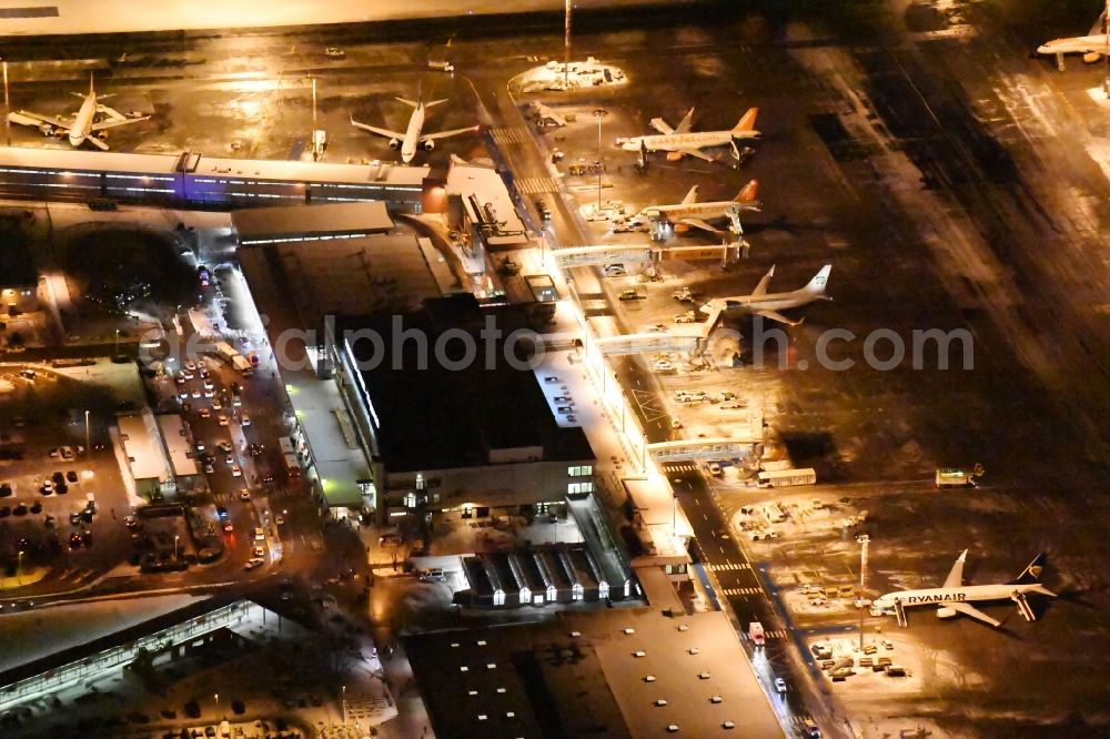 Schönefeld at night from above - Night image of wintry snowy area and main building of the airport Berlin-Schoenefeld SXF in Schoenefeld in the state of Brandenburg