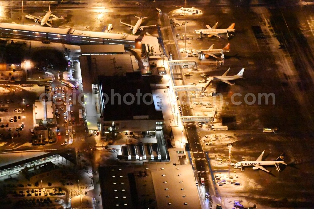 Schönefeld at night from the bird perspective: Night image of wintry snowy area and main building of the airport Berlin-Schoenefeld SXF in Schoenefeld in the state of Brandenburg