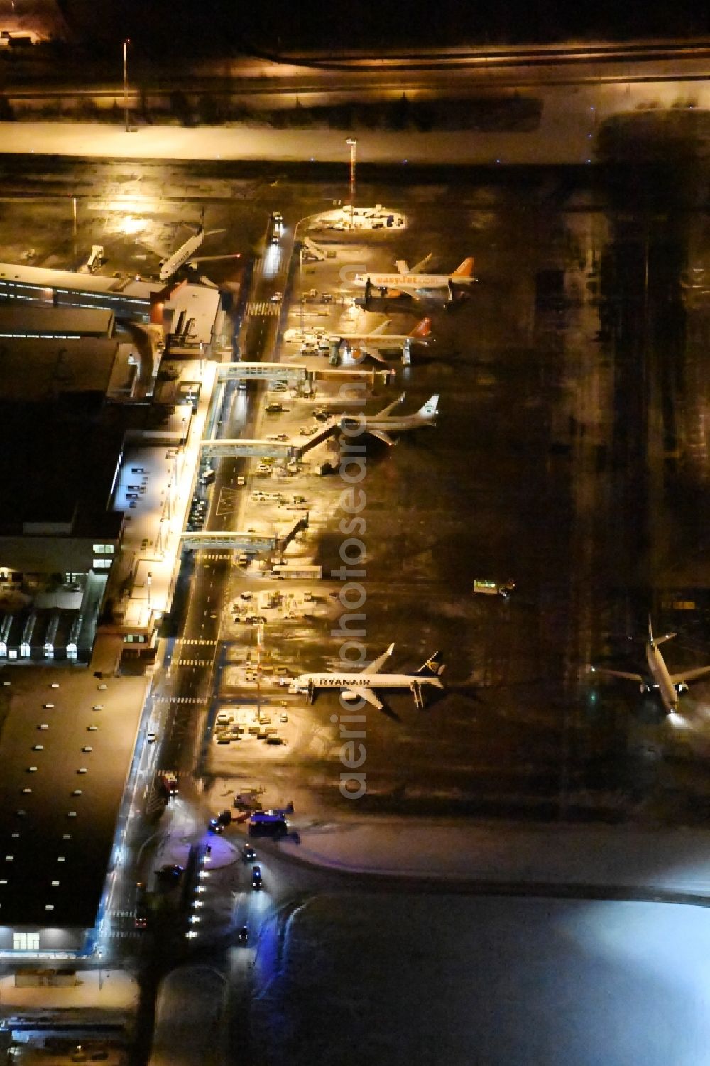 Aerial photograph at night Schönefeld - Night image of wintry snowy area and main building of the airport Berlin-Schoenefeld SXF in Schoenefeld in the state of Brandenburg