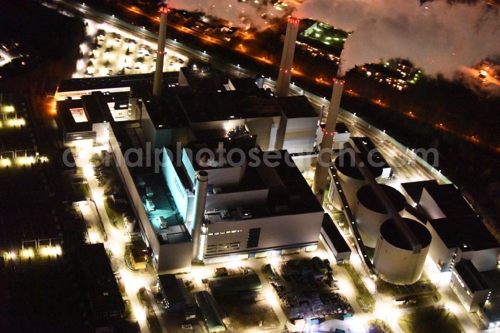 München at night from the bird perspective: Night Aerial view of the power plants of the CHP plant SWM Heizkraftwerk North Unterfoehring in Munich in Bavaria