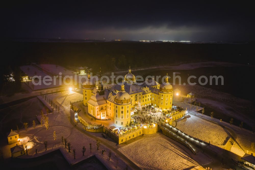 Moritzburg at night from the bird perspective: Night lights and illumination Christmas market at the hunting and moated castle in the castle pond in Moritzburg in the federal state of Saxony, Germany