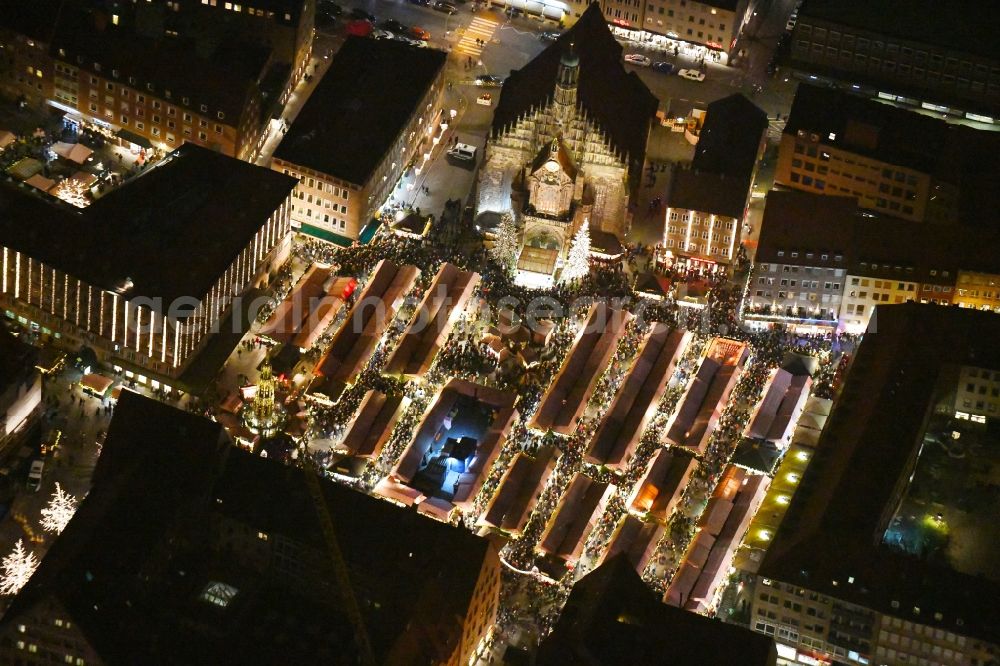 Aerial image at night Nürnberg - Night lighting Christmassy market event grounds and sale huts and booths on Platz of Nuernberger Hauptmarkt in Nuremberg in the state Bavaria, Germany