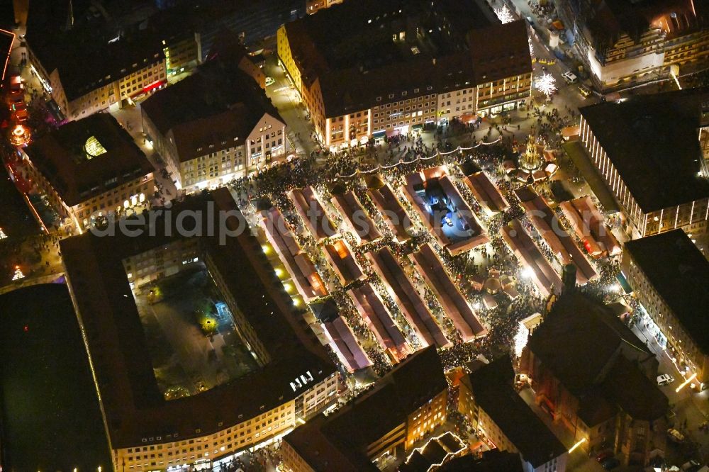 Aerial image at night Nürnberg - Night lighting Christmassy market event grounds and sale huts and booths on Platz of Nuernberger Hauptmarkt in Nuremberg in the state Bavaria, Germany