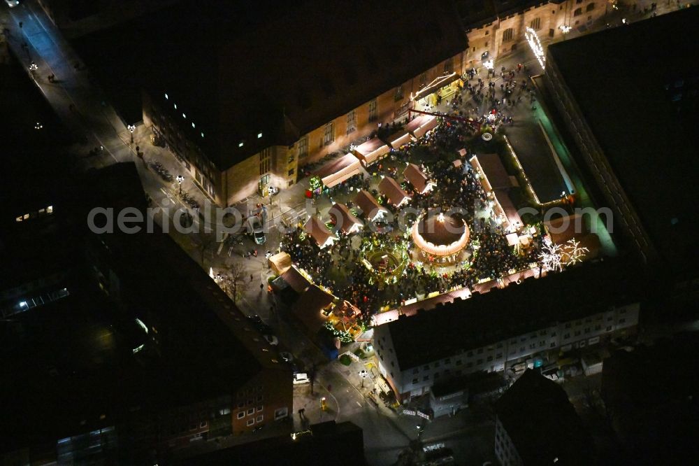 Aerial image at night Nürnberg - Night lighting Christmassy market event grounds and sale huts and booths Kinder Christkindlesmarkt on place Hans-Sachs-Platz in the district Altstadt - Sankt Sebald in Nuremberg in the state Bavaria, Germany