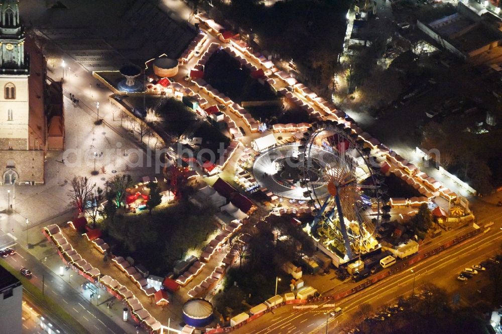 Berlin at night from above - Night view christmassy market event grounds and sale huts and booths am Neptunbrunnen in Berlin