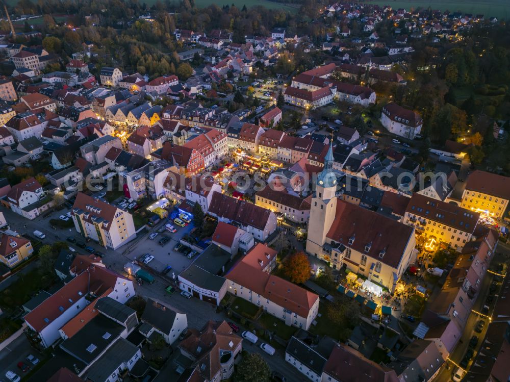 Aerial image at night Pulsnitz - Night lighting christmassy market event grounds and sale huts and booths Pfefferkuchenmarkt on street Am Markt in Pulsnitz in the state Saxony, Germany