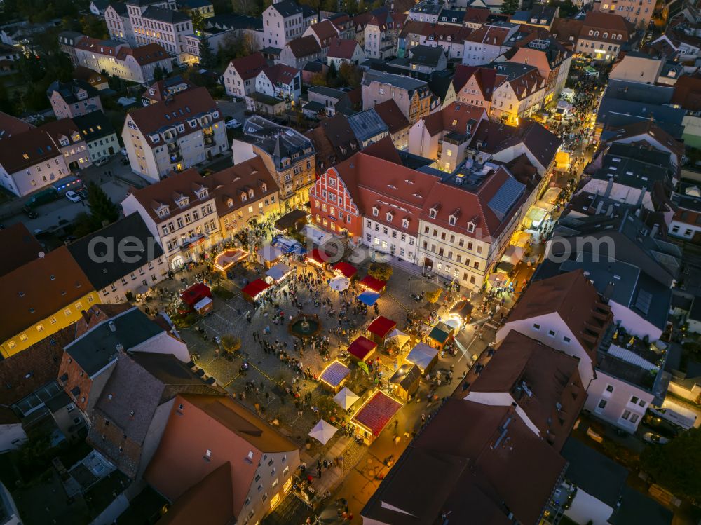 Pulsnitz at night from the bird perspective: Night lighting christmassy market event grounds and sale huts and booths Pfefferkuchenmarkt on street Am Markt in Pulsnitz in the state Saxony, Germany