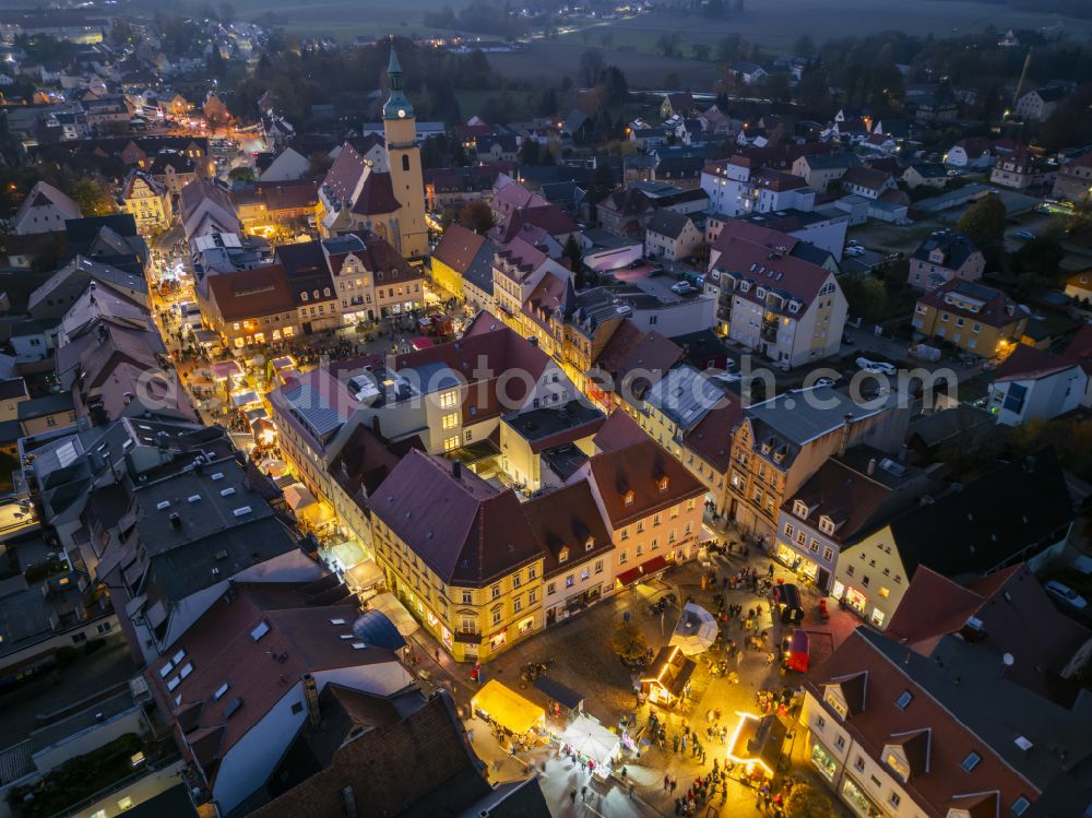 Aerial image at night Pulsnitz - Night lighting christmassy market event grounds and sale huts and booths Pfefferkuchenmarkt on street Am Markt in Pulsnitz in the state Saxony, Germany