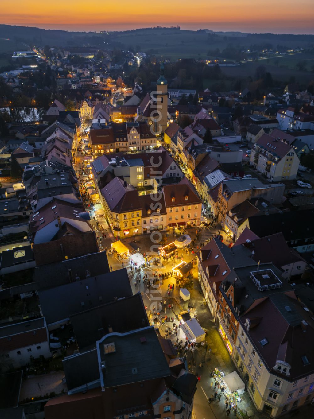 Pulsnitz at night from the bird perspective: Night lighting christmassy market event grounds and sale huts and booths Pfefferkuchenmarkt on street Am Markt in Pulsnitz in the state Saxony, Germany