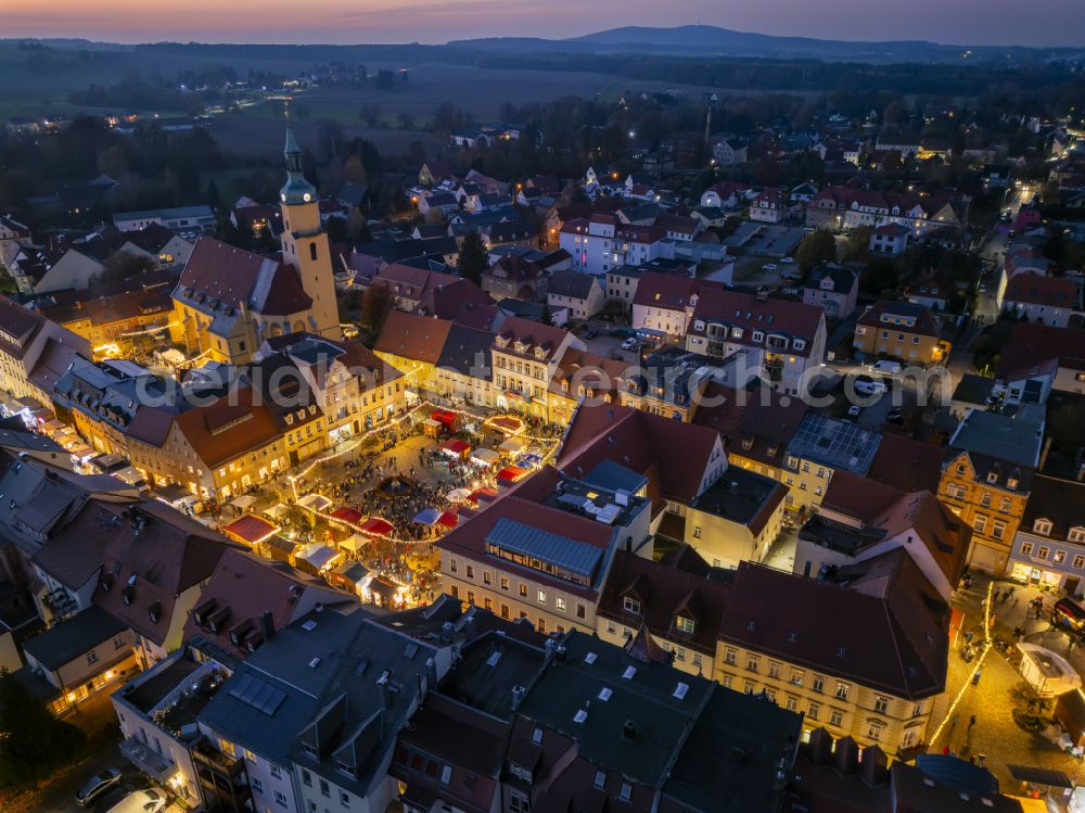 Aerial image at night Pulsnitz - Night lighting christmassy market event grounds and sale huts and booths Pfefferkuchenmarkt on street Am Markt in Pulsnitz in the state Saxony, Germany