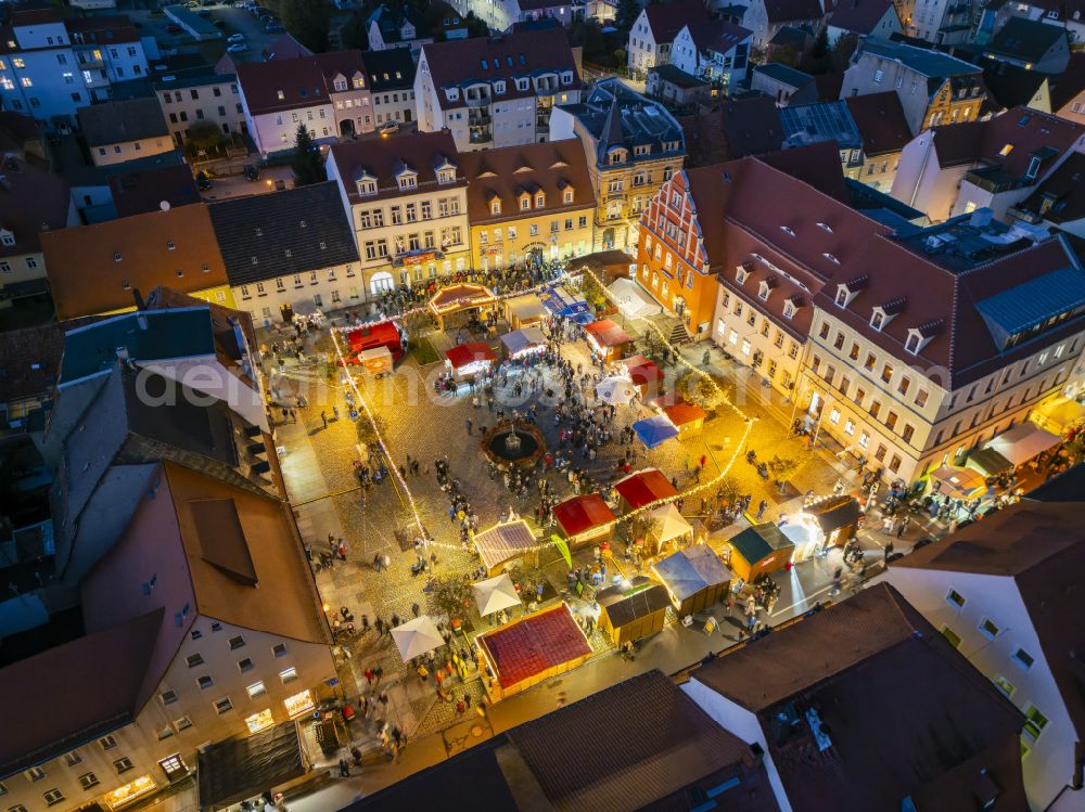 Aerial image at night Pulsnitz - Night lighting christmassy market event grounds and sale huts and booths Pfefferkuchenmarkt on street Am Markt in Pulsnitz in the state Saxony, Germany