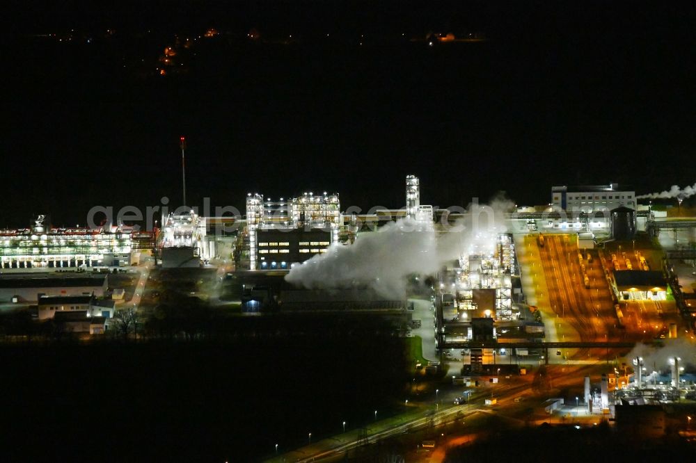 Nünchritz at night from the bird perspective: Night lighting Building and production halls on the premises of the chemical manufacturers Wacker Chemie AG, factory Nuenchritz on Friedrich-von-Heyden-Platz in Nuenchritz in the state Saxony, Germany