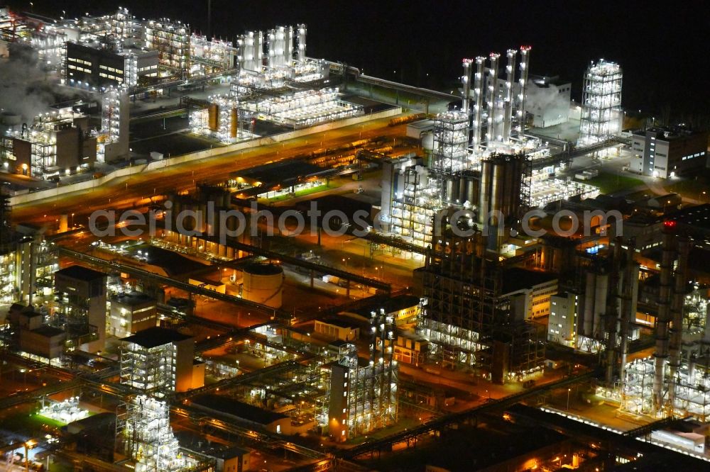 Nünchritz at night from the bird perspective: Night lighting Building and production halls on the premises of the chemical manufacturers Wacker Chemie AG, factory Nuenchritz on Friedrich-von-Heyden-Platz in Nuenchritz in the state Saxony, Germany