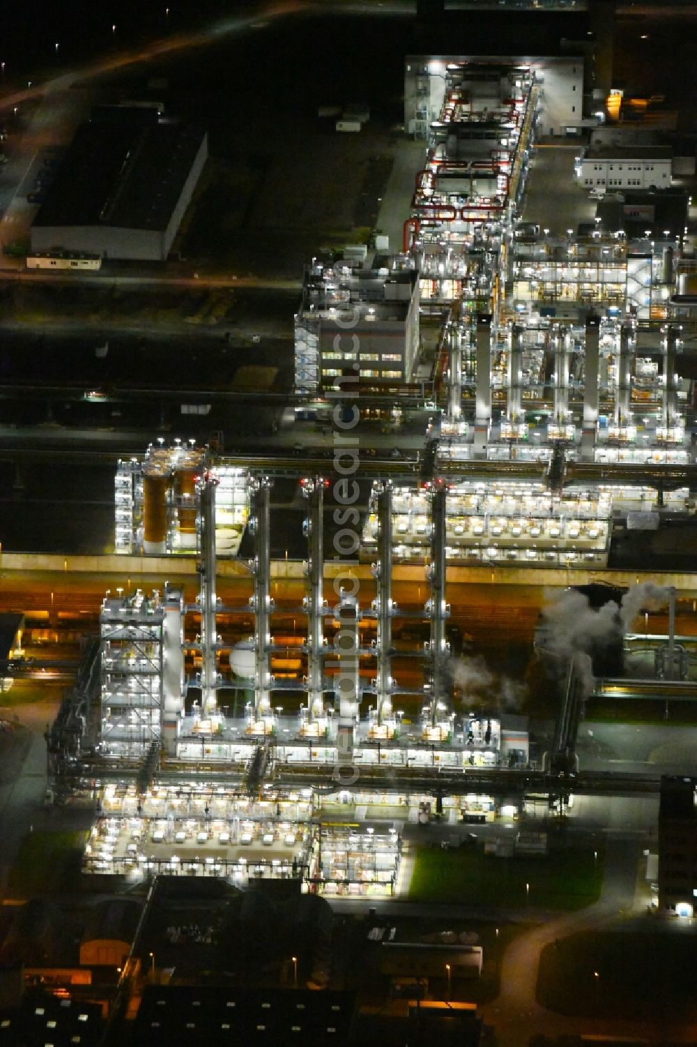 Nünchritz at night from the bird perspective: Night lighting Building and production halls on the premises of the chemical manufacturers Wacker Chemie AG, factory Nuenchritz on Friedrich-von-Heyden-Platz in Nuenchritz in the state Saxony, Germany