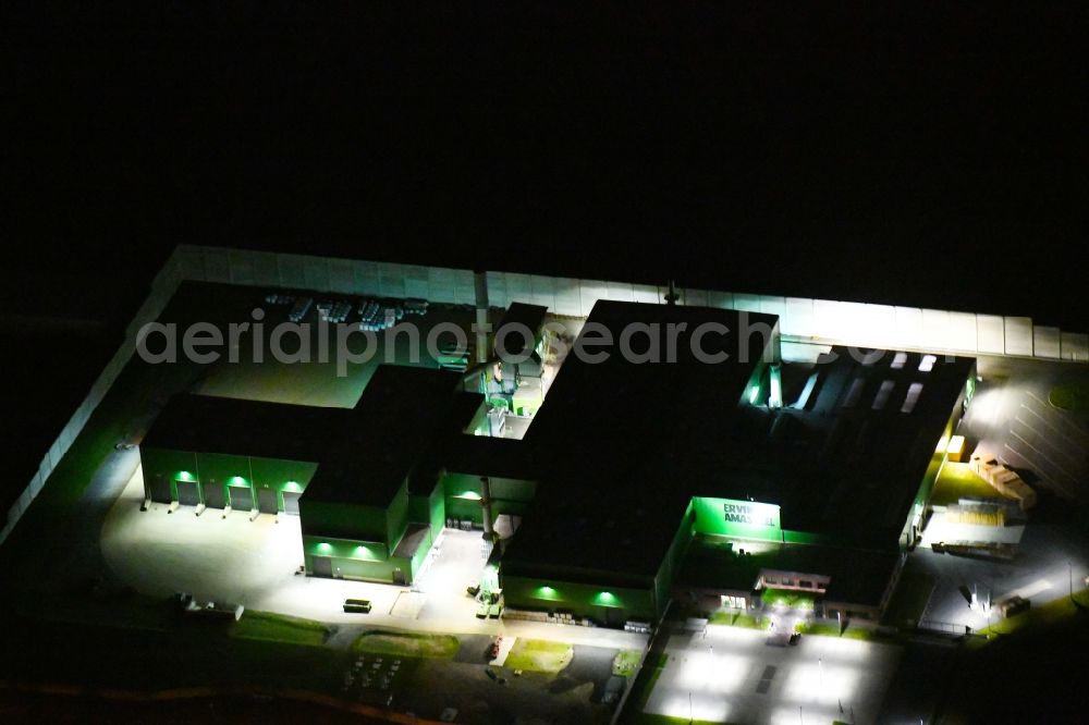 Aerial image at night Glaubitz - Night lighting Building and production halls on the premises of Ervin Amasteel on Industriestrasse in Glaubitz in the state Saxony, Germany