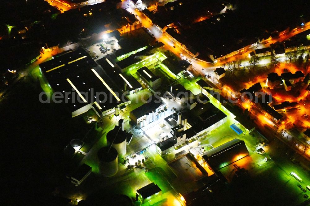 Kyritz at night from the bird perspective: Night lighting building and production halls on the premises of Kyritzer Staerke GmbH in Kyritz in the state Brandenburg, Germany