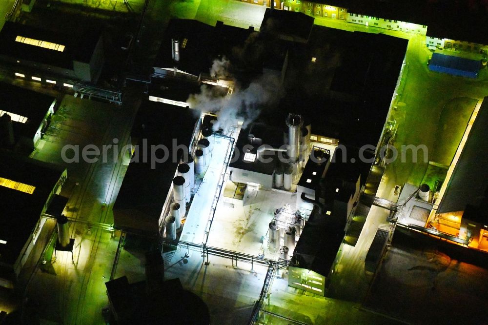 Aerial photograph at night Kyritz - Night lighting building and production halls on the premises of Kyritzer Staerke GmbH in Kyritz in the state Brandenburg, Germany