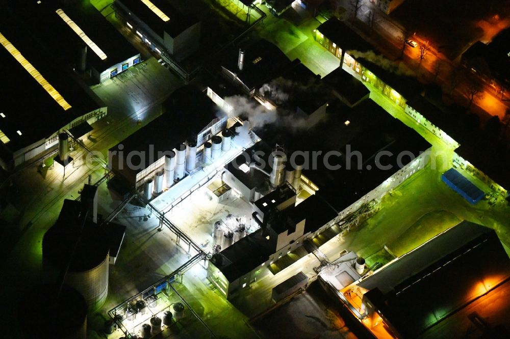 Aerial image at night Kyritz - Night lighting building and production halls on the premises of Kyritzer Staerke GmbH in Kyritz in the state Brandenburg, Germany