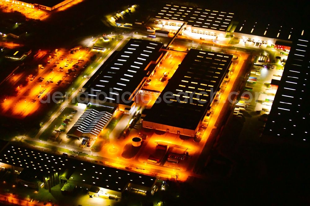 Nauen at night from the bird perspective: Night lighting building and production halls on the premises of BSH Hausgeraete GmbH on Siemensring in Nauen in the state Brandenburg, Germany