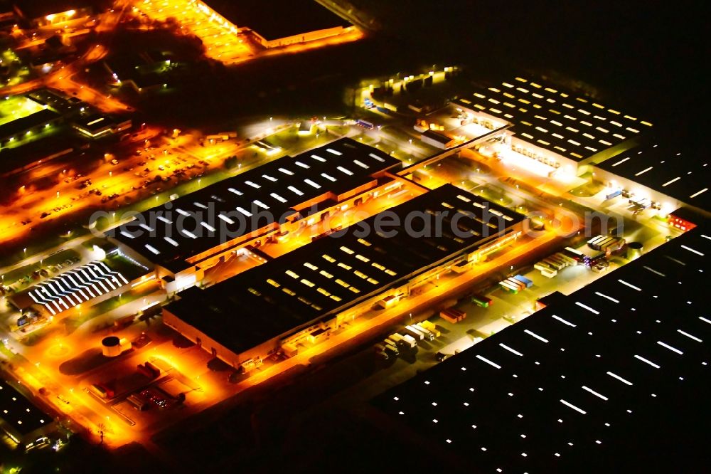 Aerial photograph at night Nauen - Night lighting building and production halls on the premises of BSH Hausgeraete GmbH on Siemensring in Nauen in the state Brandenburg, Germany