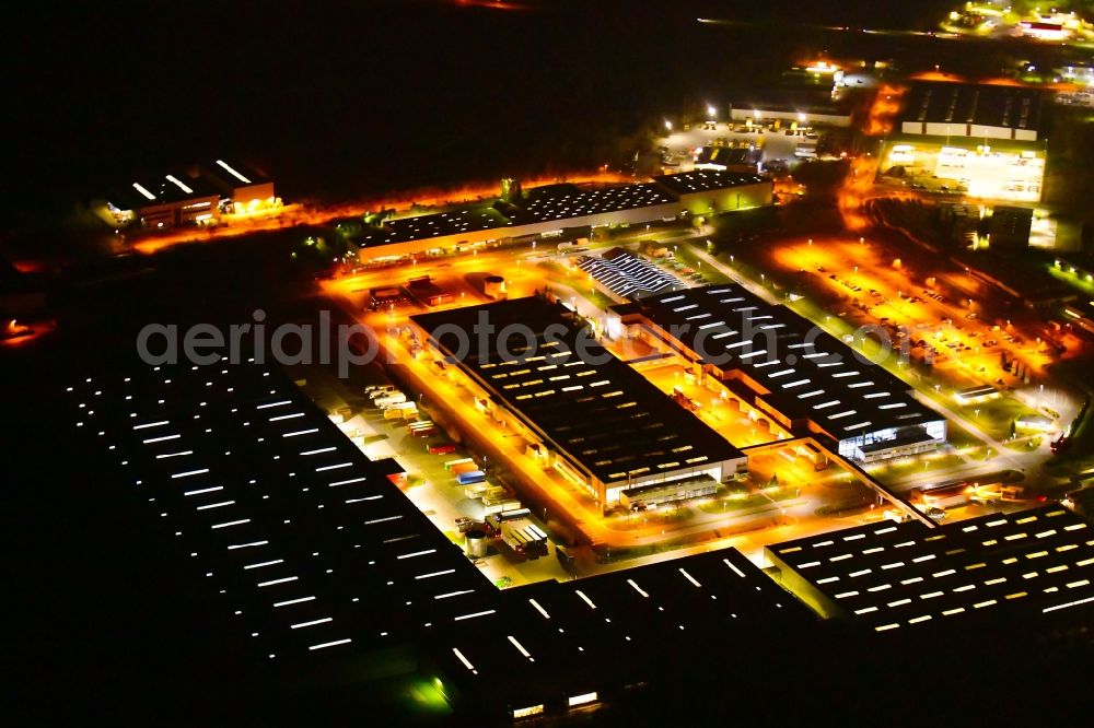 Nauen at night from the bird perspective: Night lighting building and production halls on the premises of BSH Hausgeraete GmbH on Siemensring in Nauen in the state Brandenburg, Germany