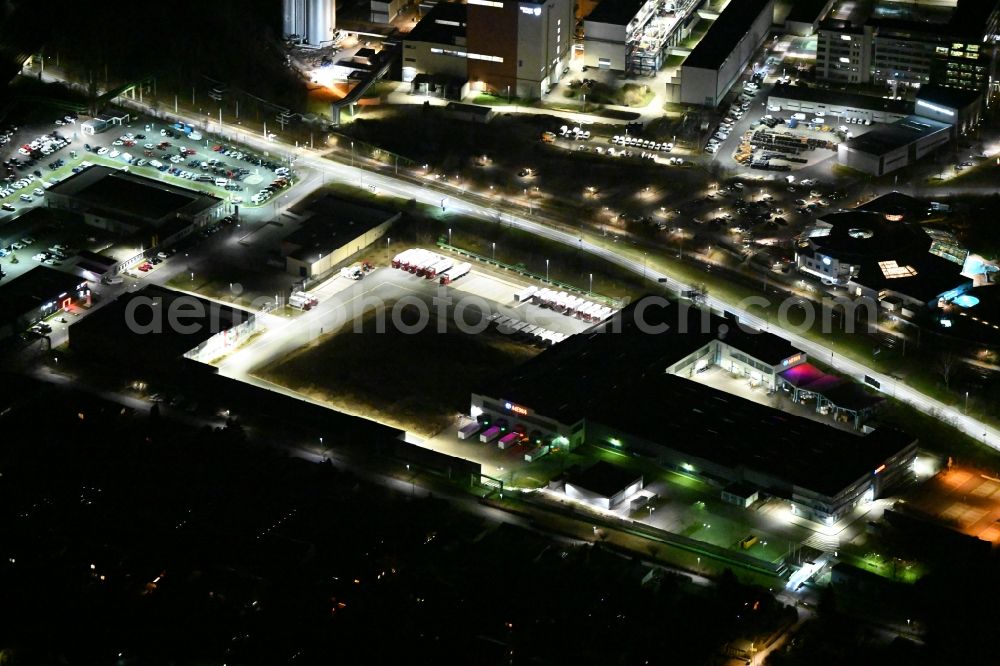 Jena at night from the bird perspective: Night lighting building and production halls on the premises MEWA Textil-Service AG & Co. Deutschland OHG in the district Burgau in Jena in the state Thuringia, Germany